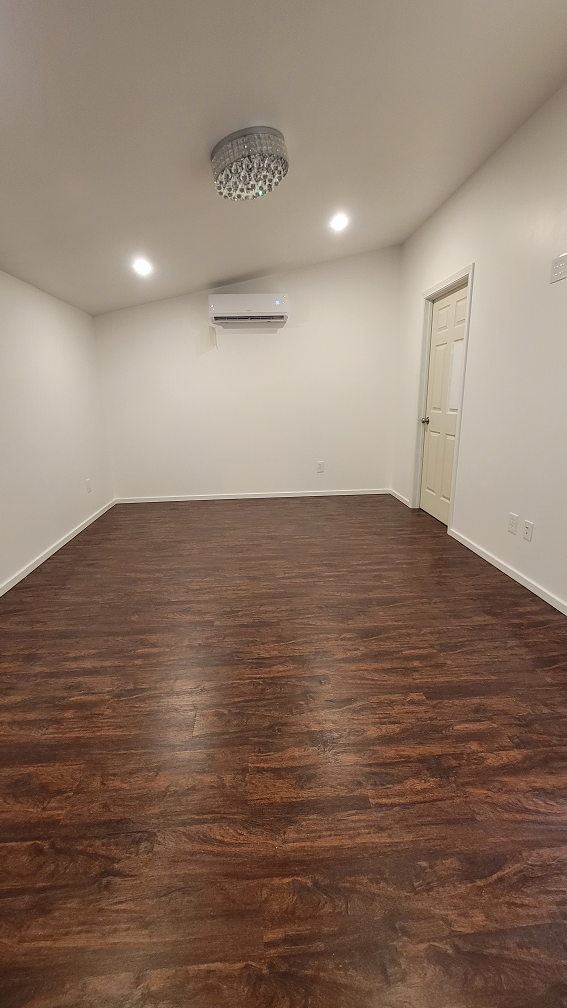 Newly remodeled bedroom with vinyl plank flooring, recessed lighting, and mini-split AC in Los Angeles