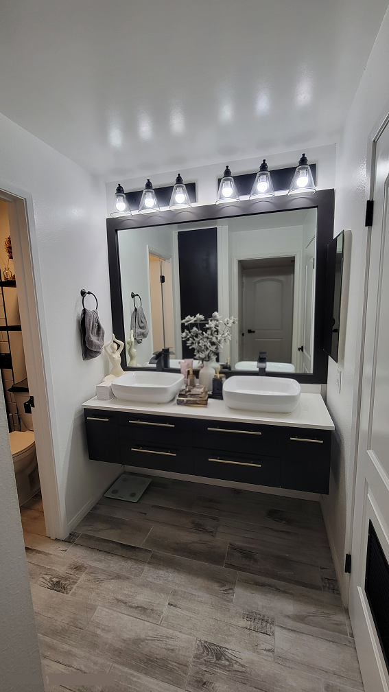 Contemporary bathroom remodel with double vanity, framed mirrors, and tile flooring