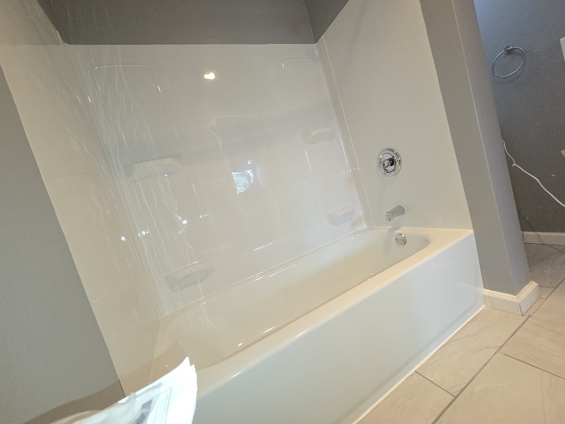 New bathtub and acrylic shower walls installed during bathroom remodel.