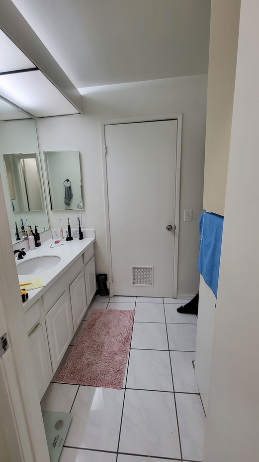 Bathroom renovation phase with original vanity and tile flooring.