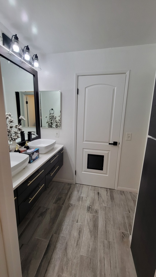 Finished bathroom renovation with updated vanity, mirrors, and modern finishes.