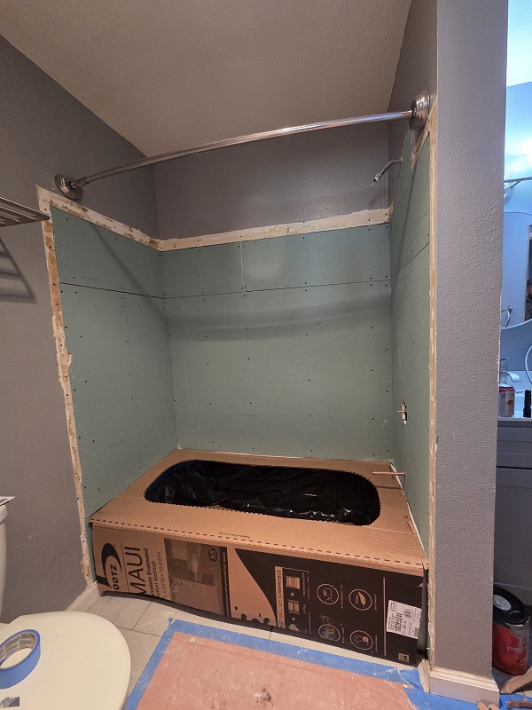 Tub and shower renovation in progress with new moisture-resistant backing installed.