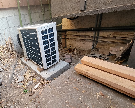 Outdoor HVAC condenser installation with new concrete pad and upgraded electrical connections.