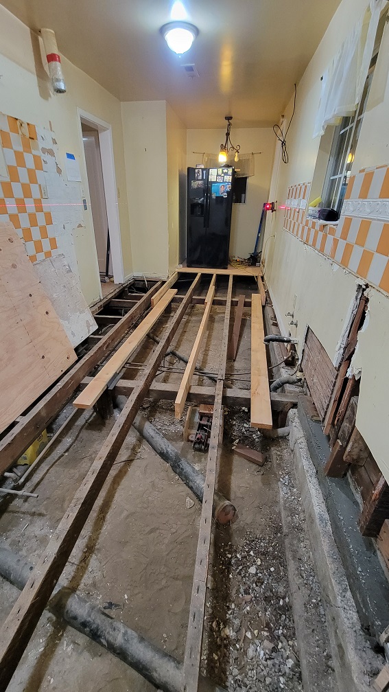 Floor demolition and plumbing exposure during full kitchen remodel.