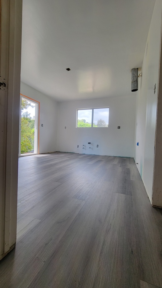 Kitchen remodel with new flooring installation and primed walls.