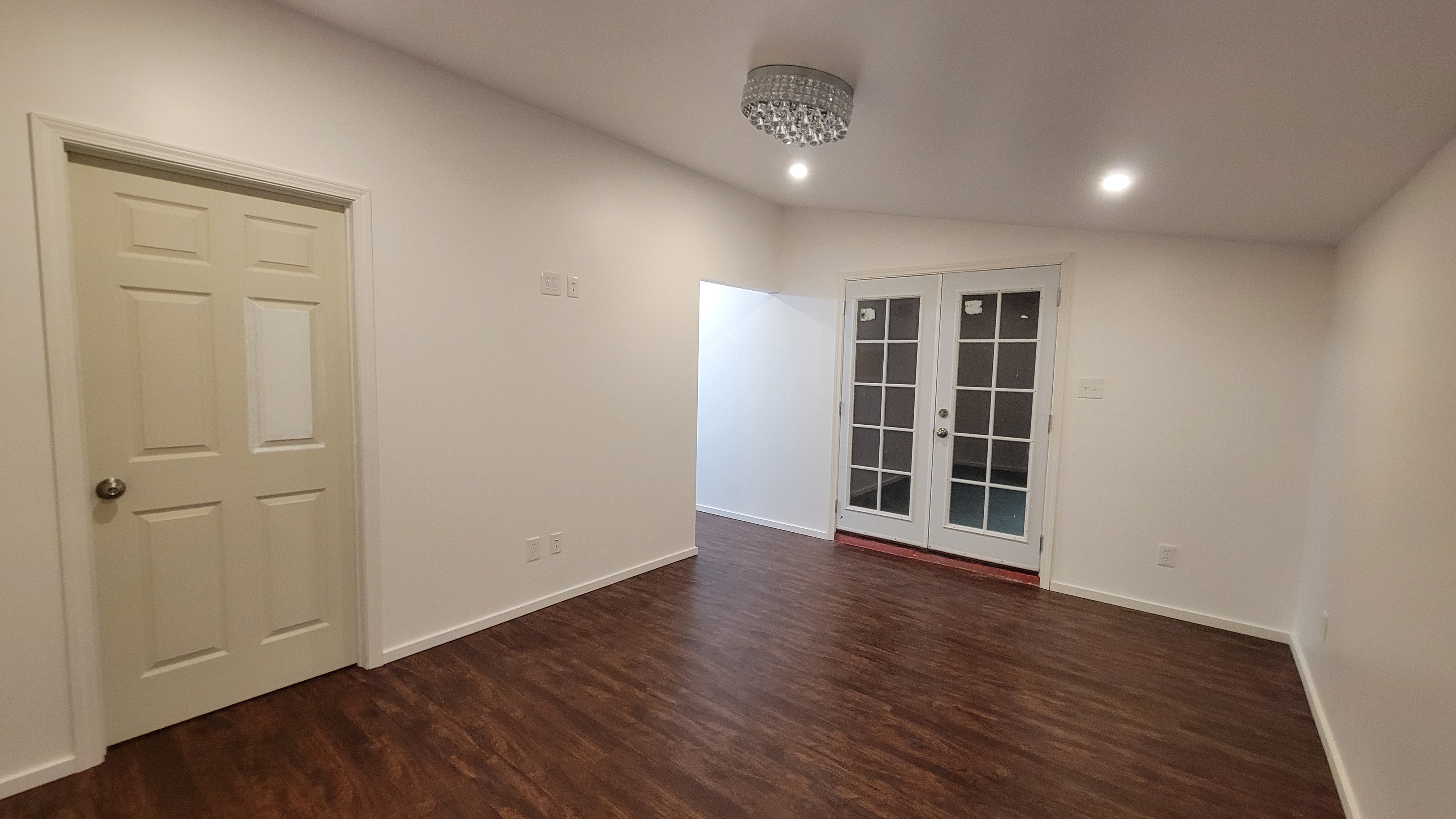 Completed bedroom remodel with vinyl plank flooring and recessed lighting.